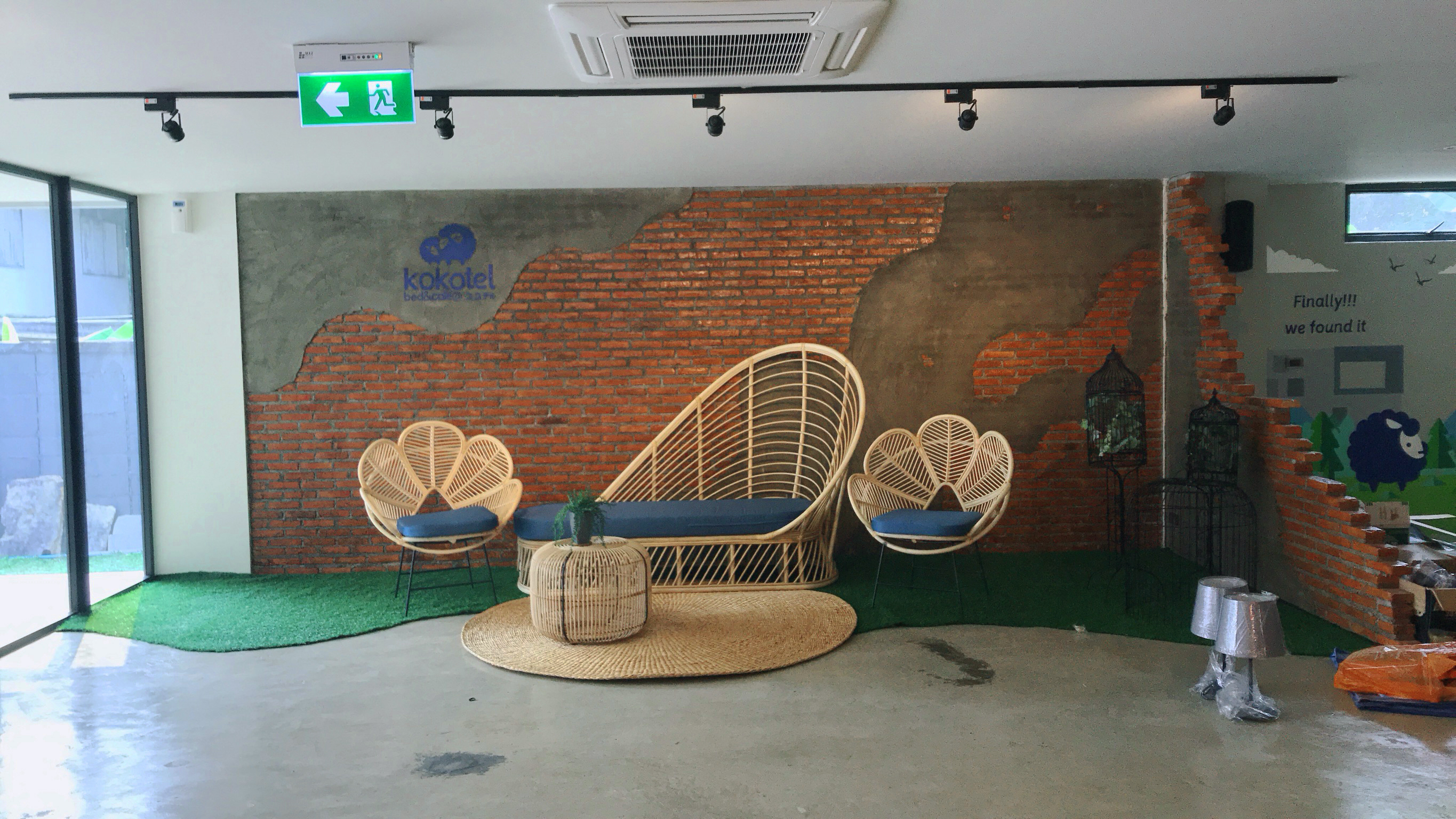 Kokotel rattan chairs and daybed against brick wall