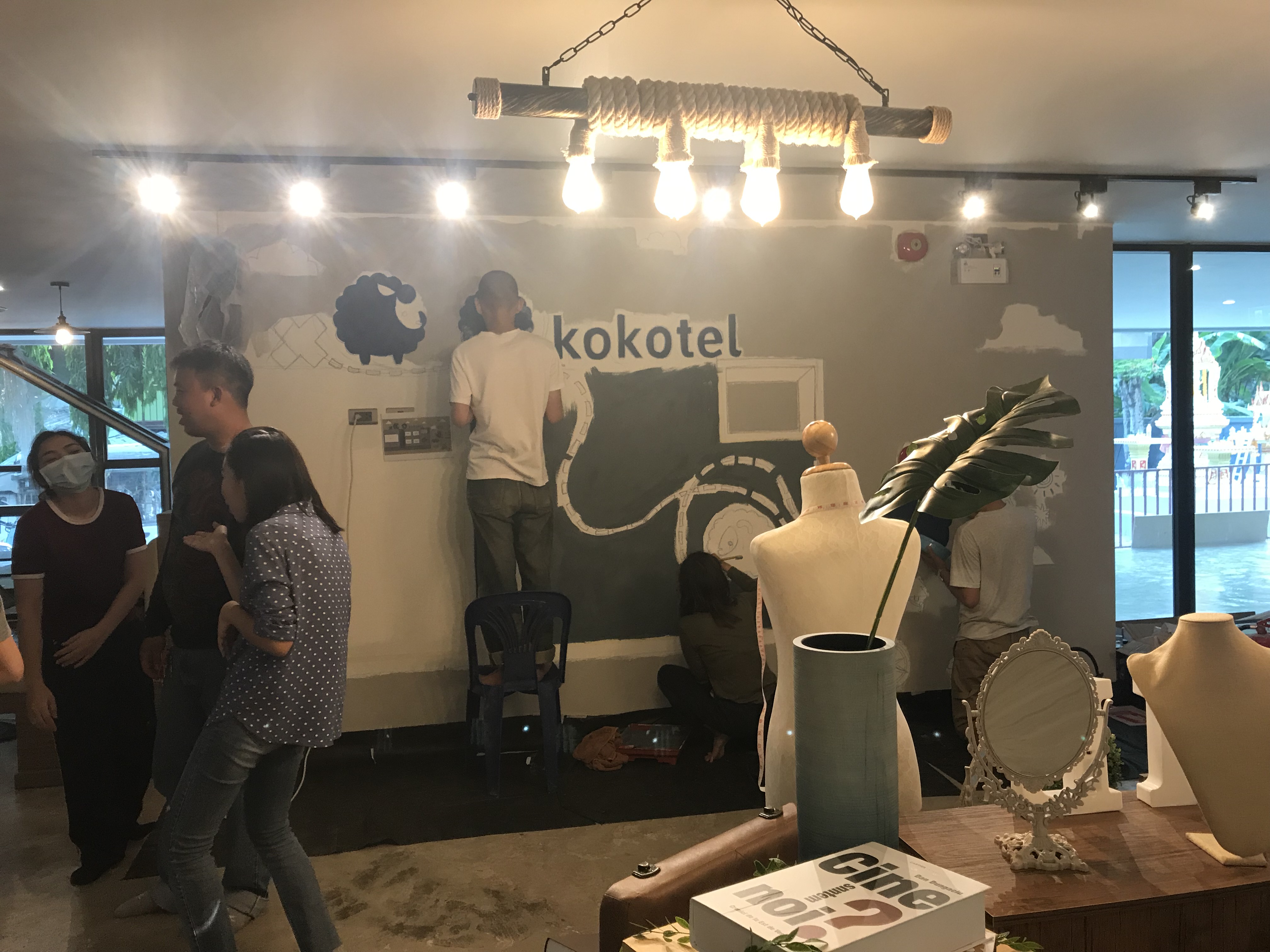 Team hand-painting the Kokotel sheep mural on site